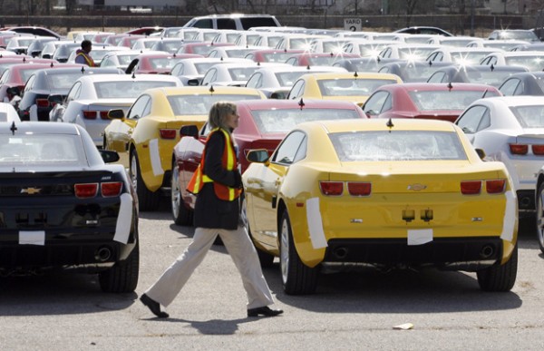 A worker walks by 2010 Chevy Camaro''s in a holding yard at the General Motors assembly plant in Oshawa
