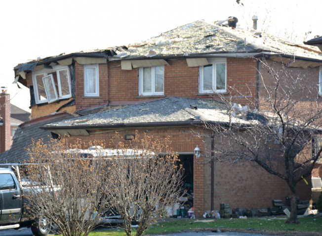 紧挨发生爆炸的民宅旁的房屋受损严重，屋顶上全是废墟，窗户和屋檐均破损。 （本报资料照片）