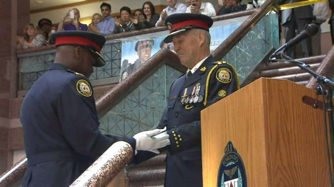 新任多伦多市警察局长桑德斯（左）与前任局长布莱尔（右）交接，正式宣誓就职。 （取材自CP24）