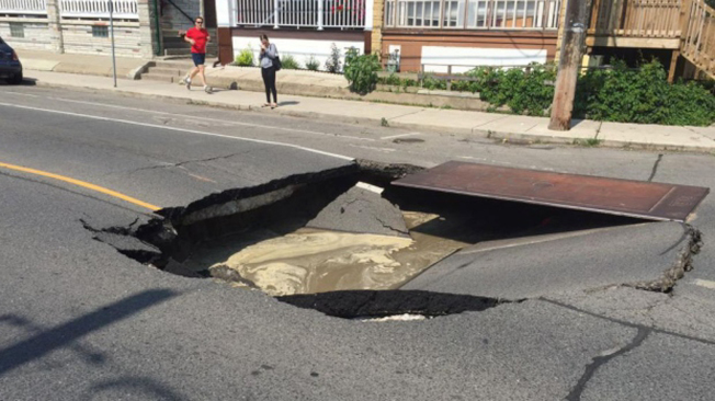 昨天下午在多倫多西部倫尼梅德路（Runnymede Road）路上，因路面塌陷，出現一個足以容納一輛汽車的巨型坑洞。（CTV）