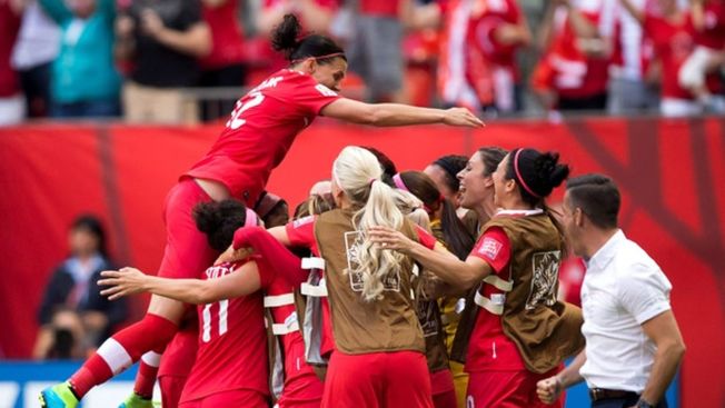 加拿大女足击败瑞士，队长辛克莱(左)兴奋得跳起来拥抱队友。 （CBC）