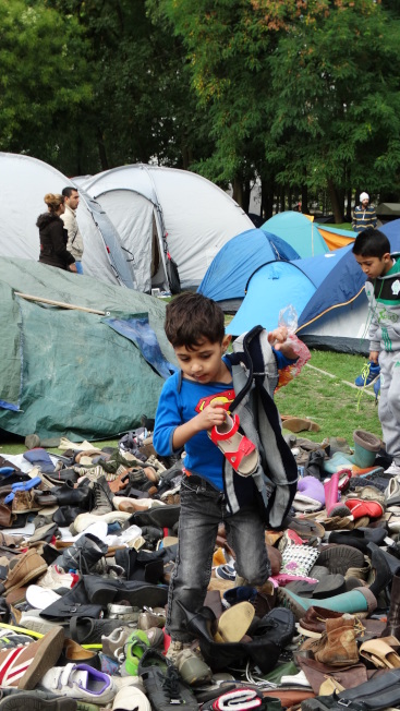 加拿大公民團體要求政府加速收容難民。圖為在布魯塞爾難民營中的男童，在尋找適合自己的鞋子。(本報系特派記者蕭白雪／攝影)