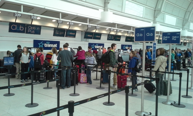 图为旅客在多伦多皮尔逊国际机场办理登机手续。（本报记者摄影）