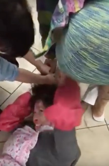华裔美甲女工被恶顾客扯住头发暴打，表情痛苦。（视频截图）