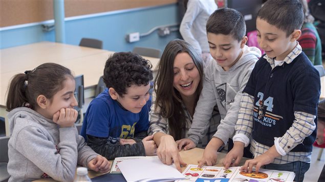 初抵加拿大的四位叙利亚孩子在跟着老师学习。
