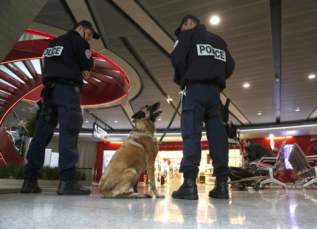 法国警察牵着警犬在巴黎戴高乐机场巡逻。 （路透）