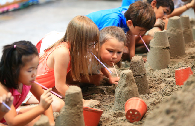 小朋友在展览会上学习做沙雕。（取材自新华社）