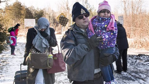加拿大边境服务处人员接待跨越加美边境的难民。