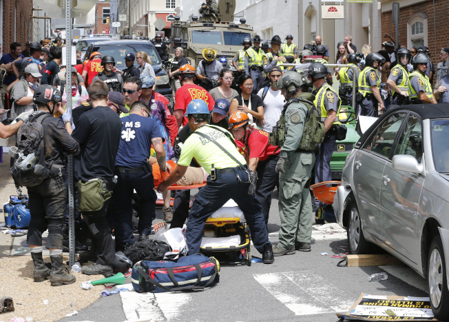 汽車衝入人群造成大量死傷後，援救人員在現場展開急救。(美聯社)