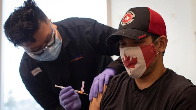 2021 年 5 月 28 日，38 岁的加拿大队轮椅橄榄球 （ wheelchair rugby）运动员 Travis Murao 在多伦多接种第二剂辉瑞 - BioNTech COVID-19 疫苗。