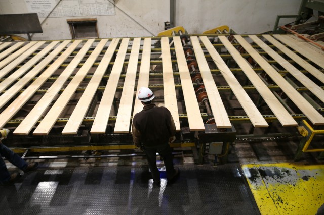 A worker inspects lumber on a conveyor belt at West Fraser Pacific Inland Resources sawmill in Smithers, British Columbia, Canada February 4, 2020. REUTERS/Jesse Winter