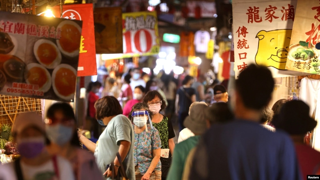 台湾台北市民众戴着口罩逛夜市。（2021年7月6日）