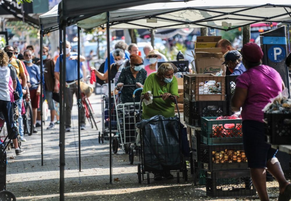 2020年8月8日，人们在美国纽约街头的免费食物发放点领取食物。新华社记者王迎摄
