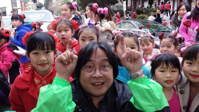Reverend Norman Fong with children at San Francisco's Chinese New Year street fair in 2020